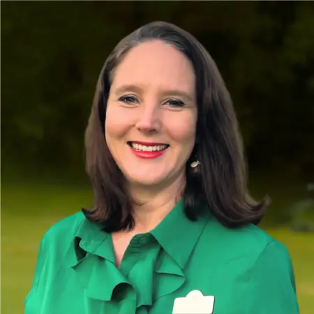 Jessica Tomlinson Hill bio image wearing a green shit in front of a natural green background