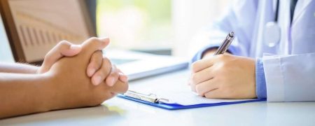 Doctor Consulting Patient While Filling up Application Form
