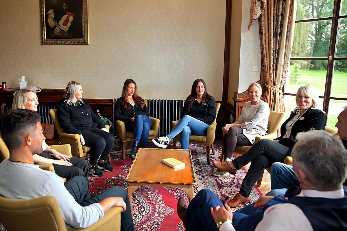 Large group therapy session by window indoors