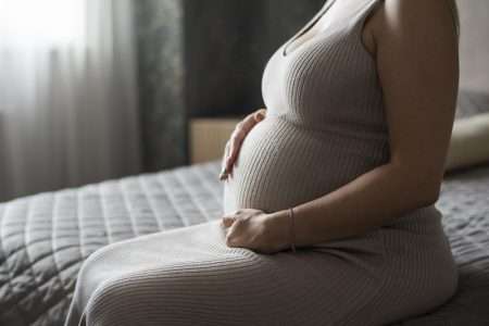 Pregnant Woman Sitting on Bed