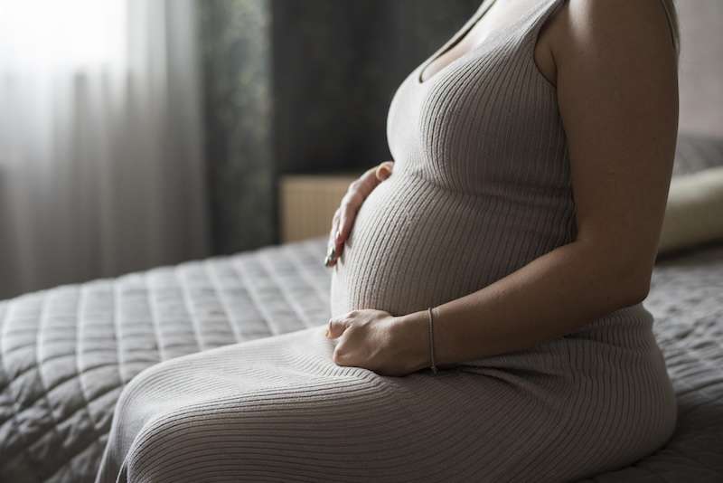 Pregnant Woman Sitting on Bed
